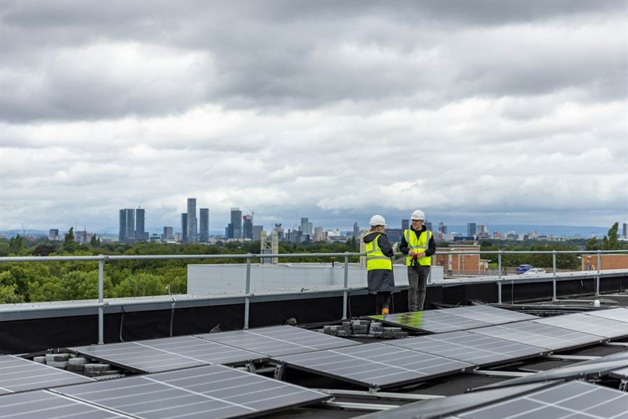 Dois profissionais conferindo a instalação de painéis solares em cobertura