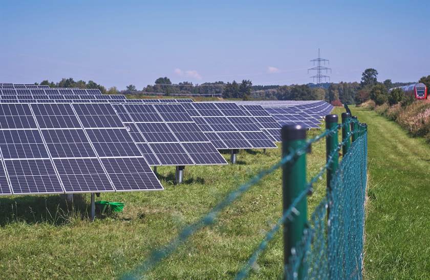 Fileiras de painéis solares instalados em solo numa propriedade rural