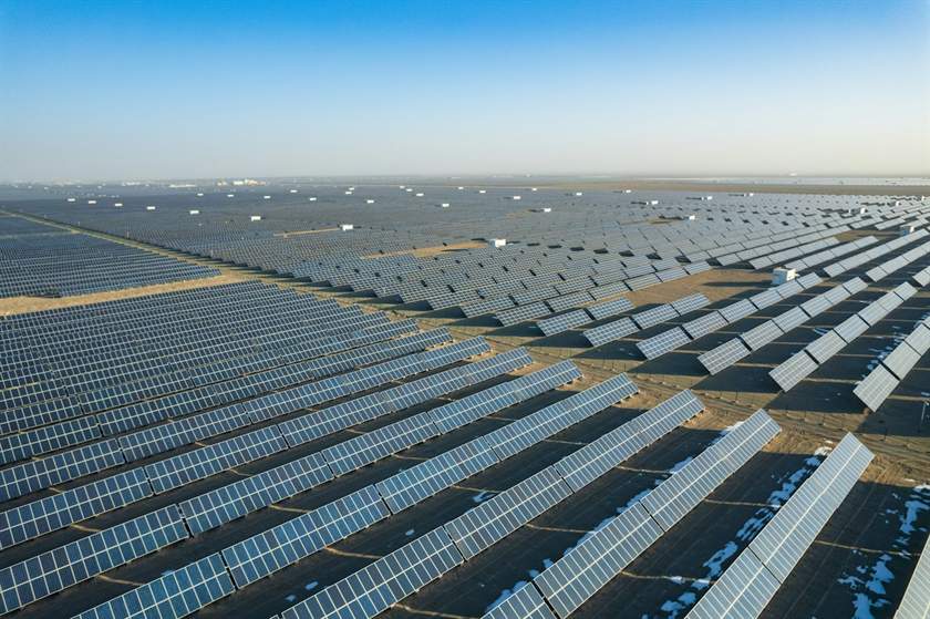 Vista aérea de usina solar com centenas de fileiras de módulos
